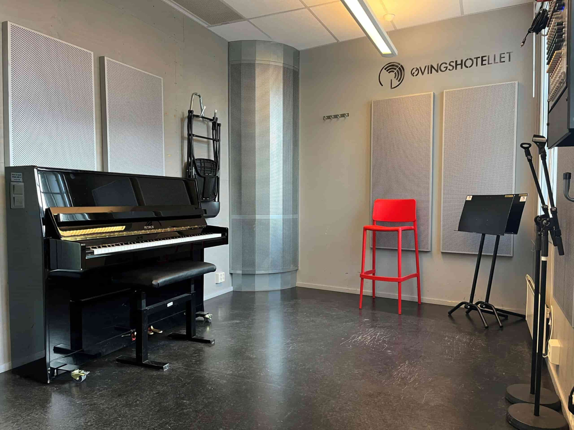 Lyst og innbydende øvingsrom med akustisk piano på Øvingshotellet i Oslo